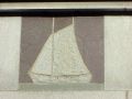 A stone tile of a sailboat in a boat house of Boston's Charles River 