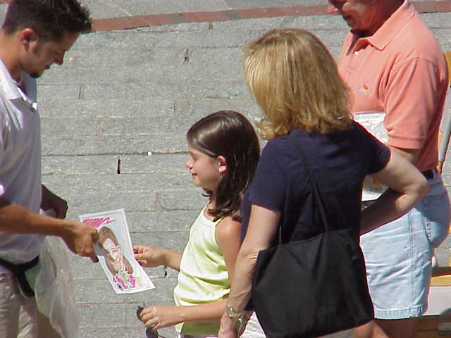 Agirl sees the characture an artist created for her at Quincy Market in Boston