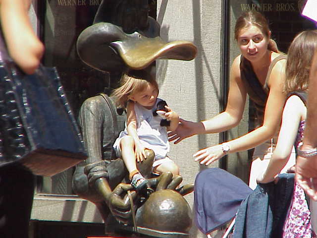 A very young girl in the lap of Duffy Dunck in Boston's Quincy Market